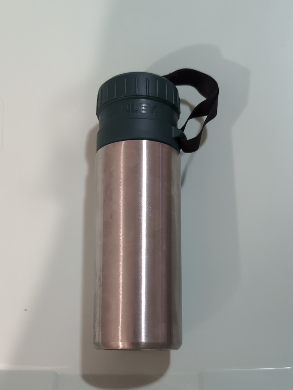 Stanley Stainless Steel Bottle with Dark Green Cap and Black Strap